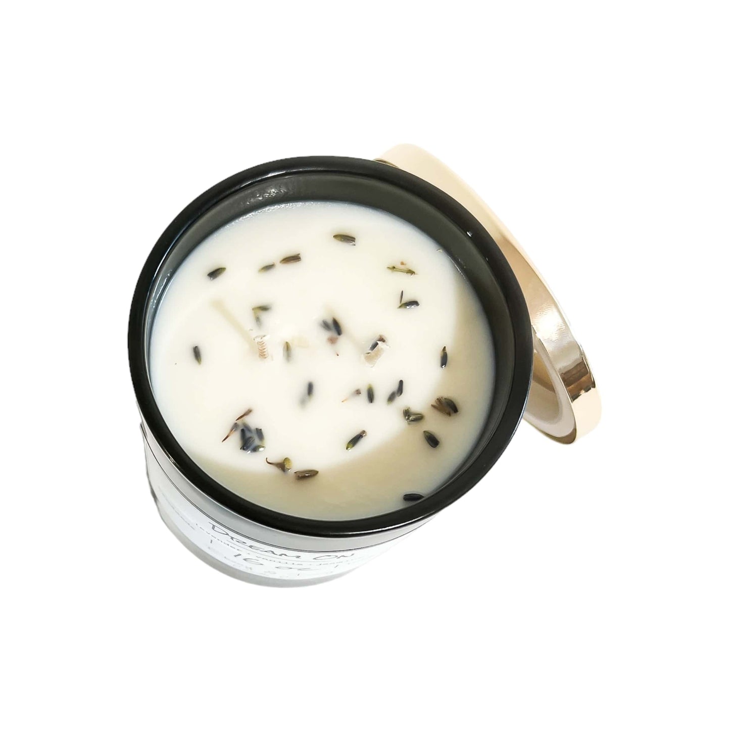 A top down shot of a black 16oz jar soy candle with dried lavender buds on top of the wax, a gold lid and a white label named Dream On, on a white background, made by Ebony & Ivory Candle Co in Lethbridge, Alberta, Canada
