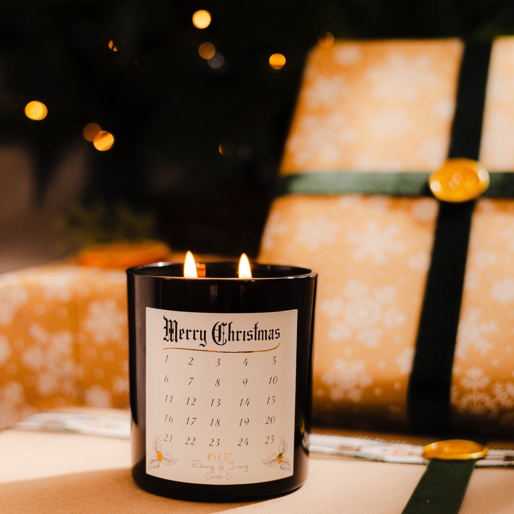 Candle with a 'Merry Christmas' label on wrapped presents with a blurred Christmas tree in the background. Advent Christmas countdown candle soy wax. #1 Christmas candle.