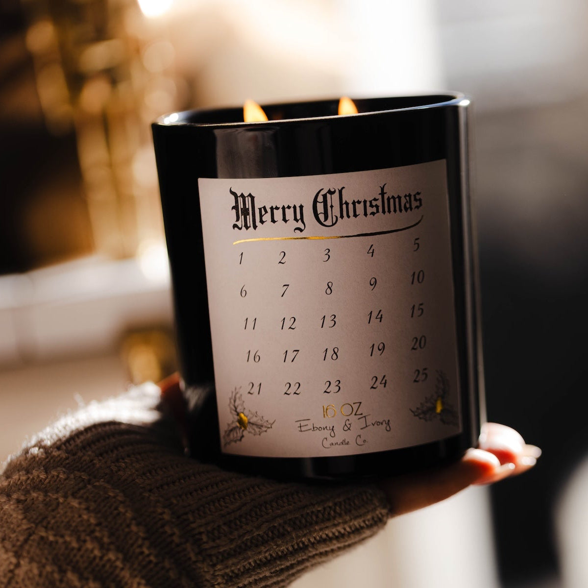Candle with a 'Merry Christmas' label on wrapped presents with a blurred Christmas tree in the background. Advent Christmas countdown candle soy wax. #1 Christmas candle.