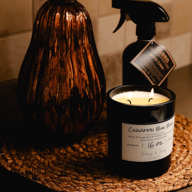 All purpose cleaner in a black bottle with kitchen setting and a candle