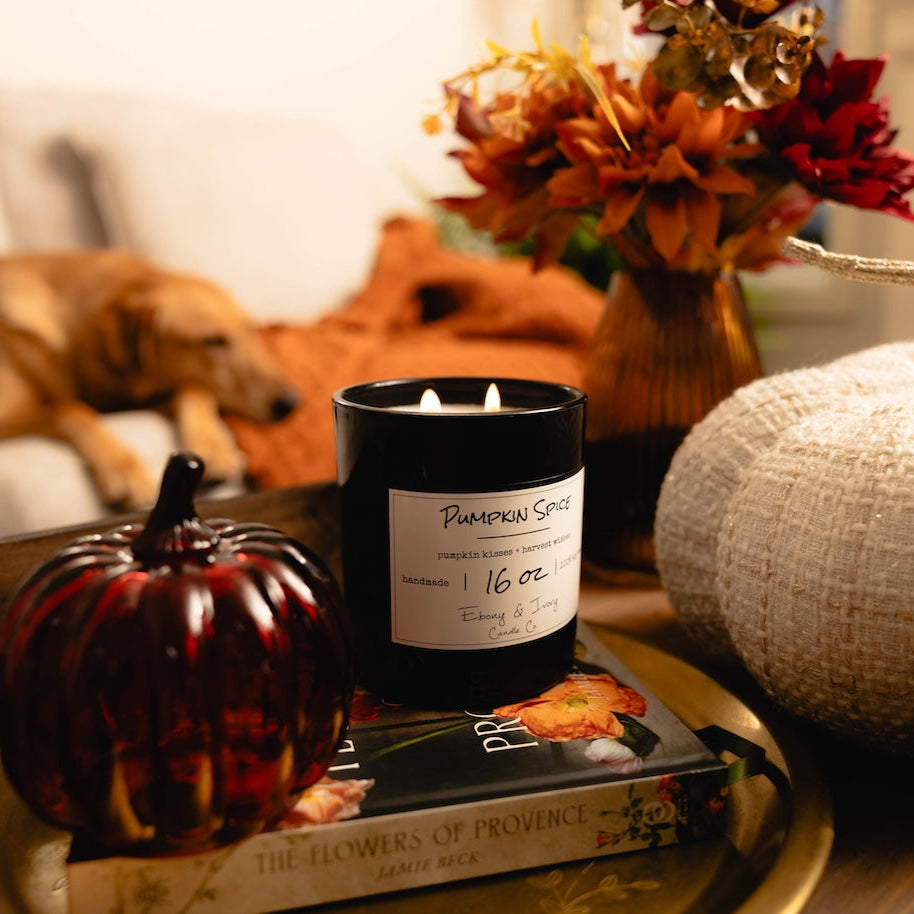 Soy Candle Canada with 'Pumpkin Spice' label on a tray with decorative pumpkins and flowers, dog in the background