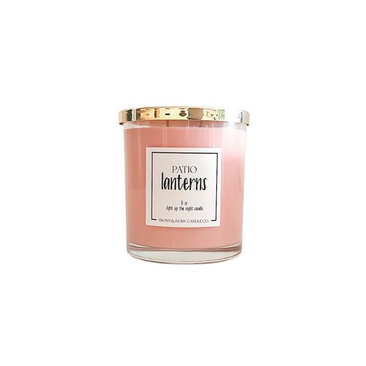 Pink candle with a gold lid and label on a white background
