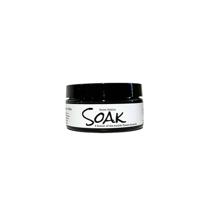 A 4oz round black jar with a white label named Green Goblin Clay Soak, on a white background, made by Ebony & Ivory Candle Co in Lethbridge, Alberta, Canada