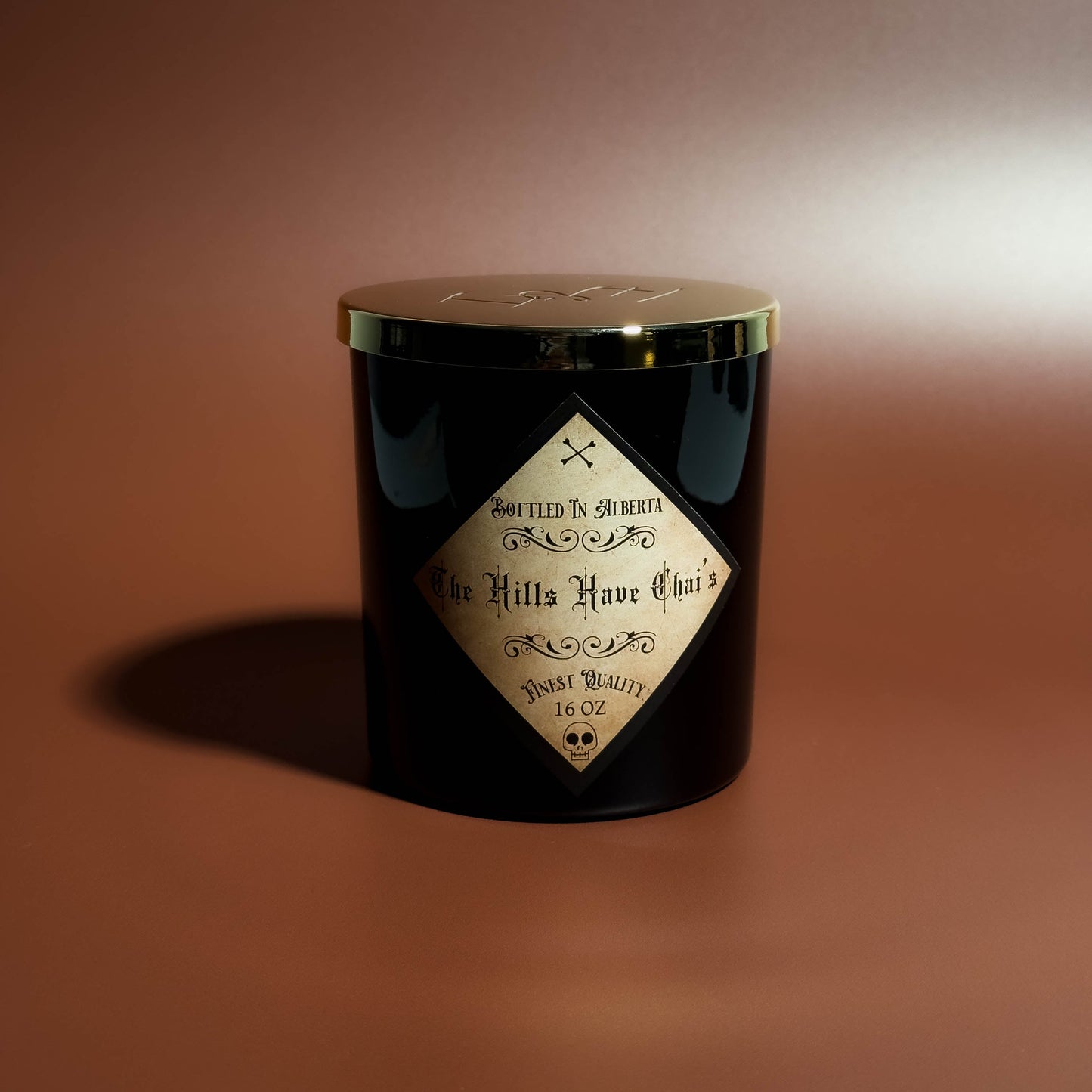 Black candle with a label on a brown background