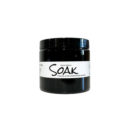 An 8oz round black jar with a white label named Green Goblin Clay Soak, on a white background, made by Ebony & Ivory Candle Co in Lethbridge, Alberta, Canada
