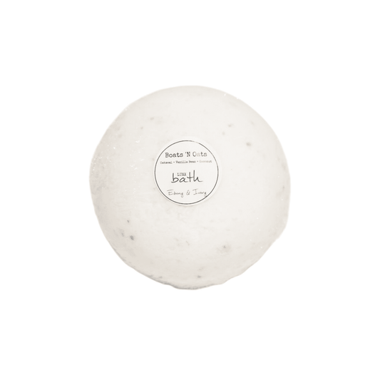 A Boats N' Oats Bath bomb with a white round label on a white background, made by Ebony & Ivory Candle Co in Lethbridge, Alberta, Canada
