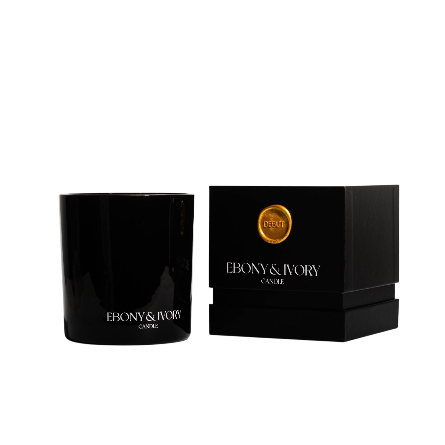 A black 18oz jar coconut soy candle with a white Ebony & Ivory on the front next to a black candle box with a gold label named Debut, on a white background, made by Ebony & Ivory Candle Co in Lethbridge, Alberta, Canada