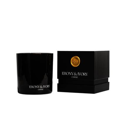 A black 18oz jar coconut soy candle with a white Ebony & Ivory on the front next to a black candle box with a gold label named Debut, on a white background, made by Ebony & Ivory Candle Co in Lethbridge, Alberta, Canada