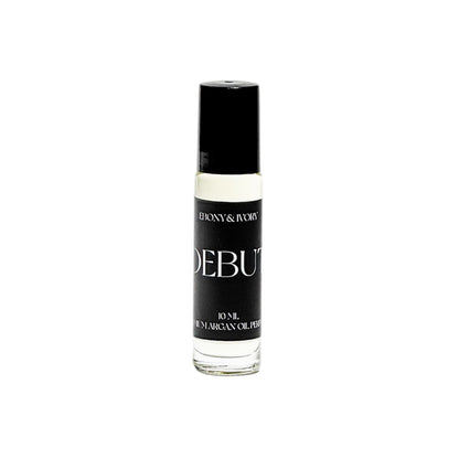 A clear 10ml bottle of argan oil perfume roll on with a black lid and a black label named DEBUT, on a white background, made by Ebony & Ivory Candle Co in Lethbridge, Alberta, Canada