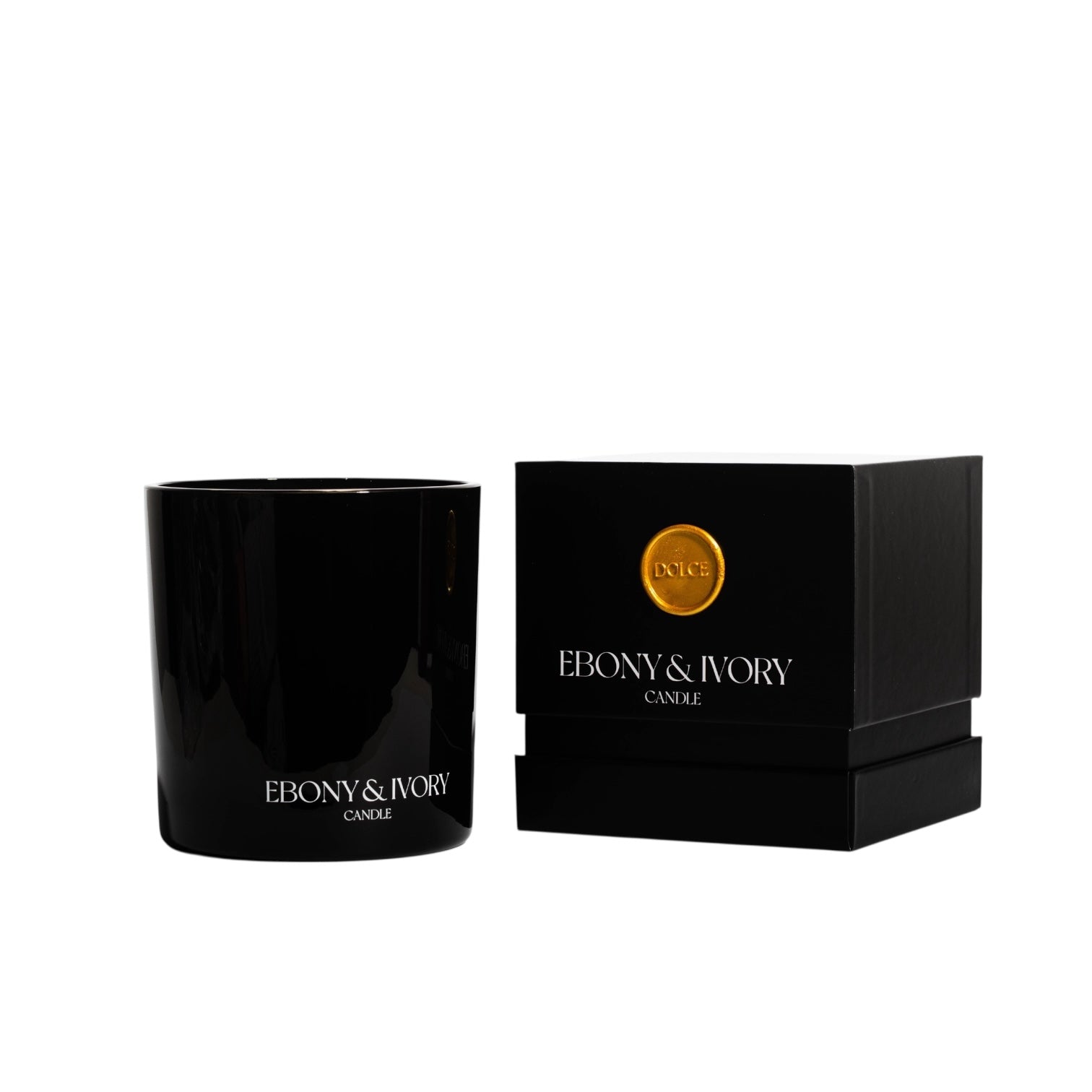 A black 18oz jar coconut soy candle with a white Ebony & Ivory on the front of it, next to a black box with a old seal label named Dolce, on a white background, made by Ebony & Ivory Candle Co in Lethbridge, Alberta, Canada