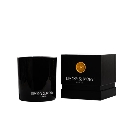 A black 18oz jar coconut soy candle with a white Ebony & Ivory on the front of it, next to a black box with a old seal label named Dolce, on a white background, made by Ebony & Ivory Candle Co in Lethbridge, Alberta, Canada