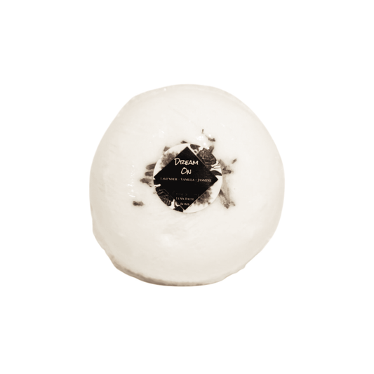 A white bath bomb with dried lavender buds on top and a round sticker label named Dream On, On a white background, made by Ebony & Ivory Candle Co in Lethbridge, Alberta, Canada