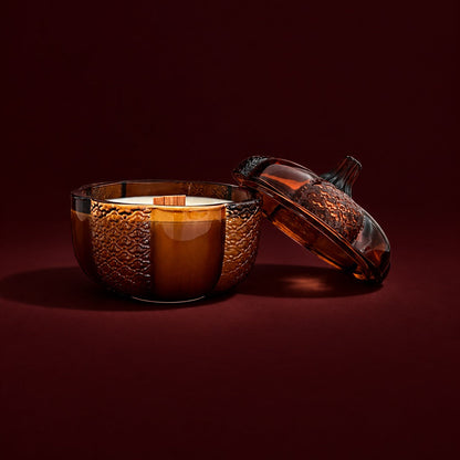 An 8oz soy wood wick soy candle in an amber heirloom pumpkin jar with the lid off.