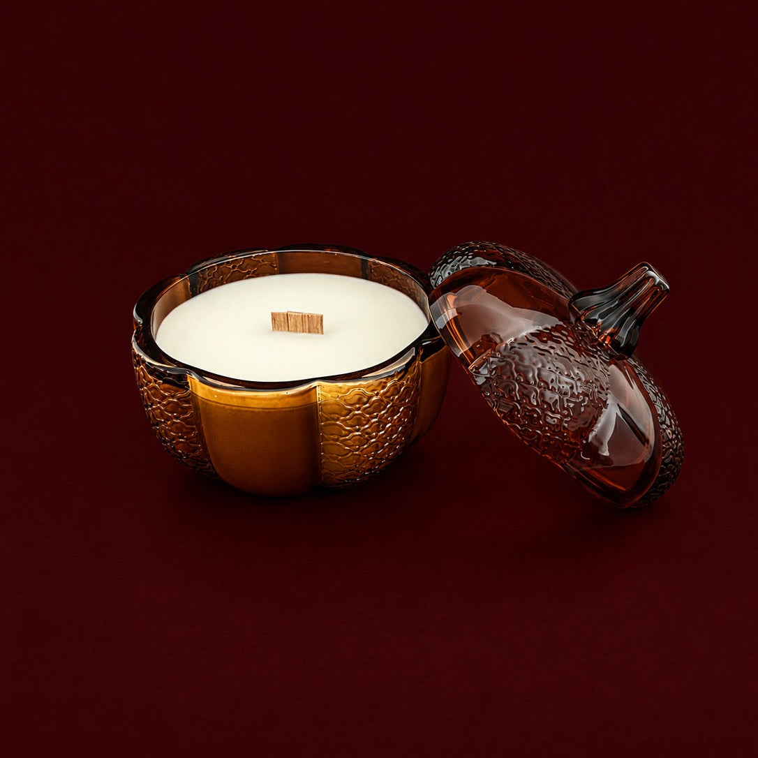 An 8oz soy wood wick soy candle in an amber heirloom pumpkin jar with the lid off, showing the inside of the candle