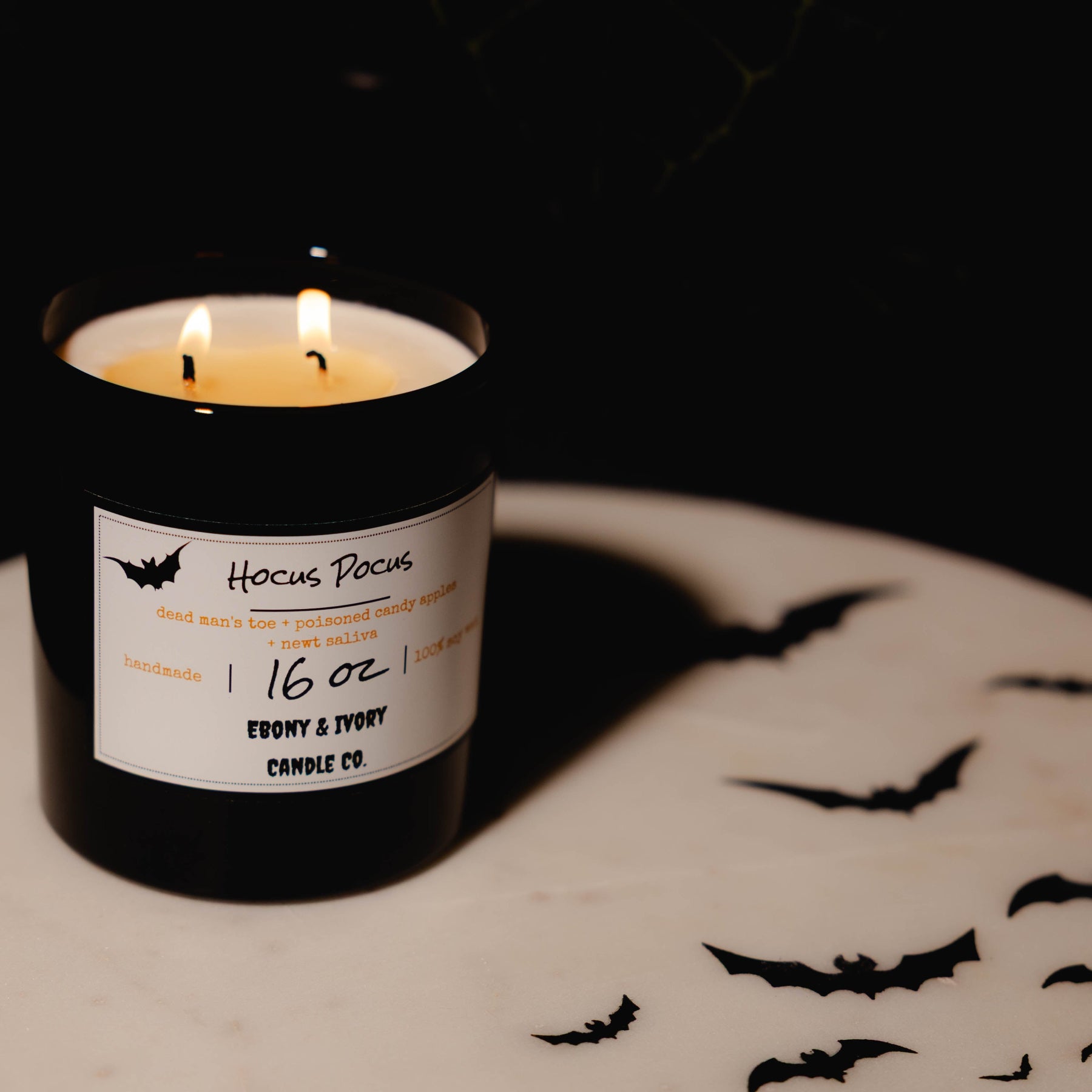 Black 16oz soy Candle with a label on a dark background. Hocus Pocus soy candle Canada. Fall season candle. 