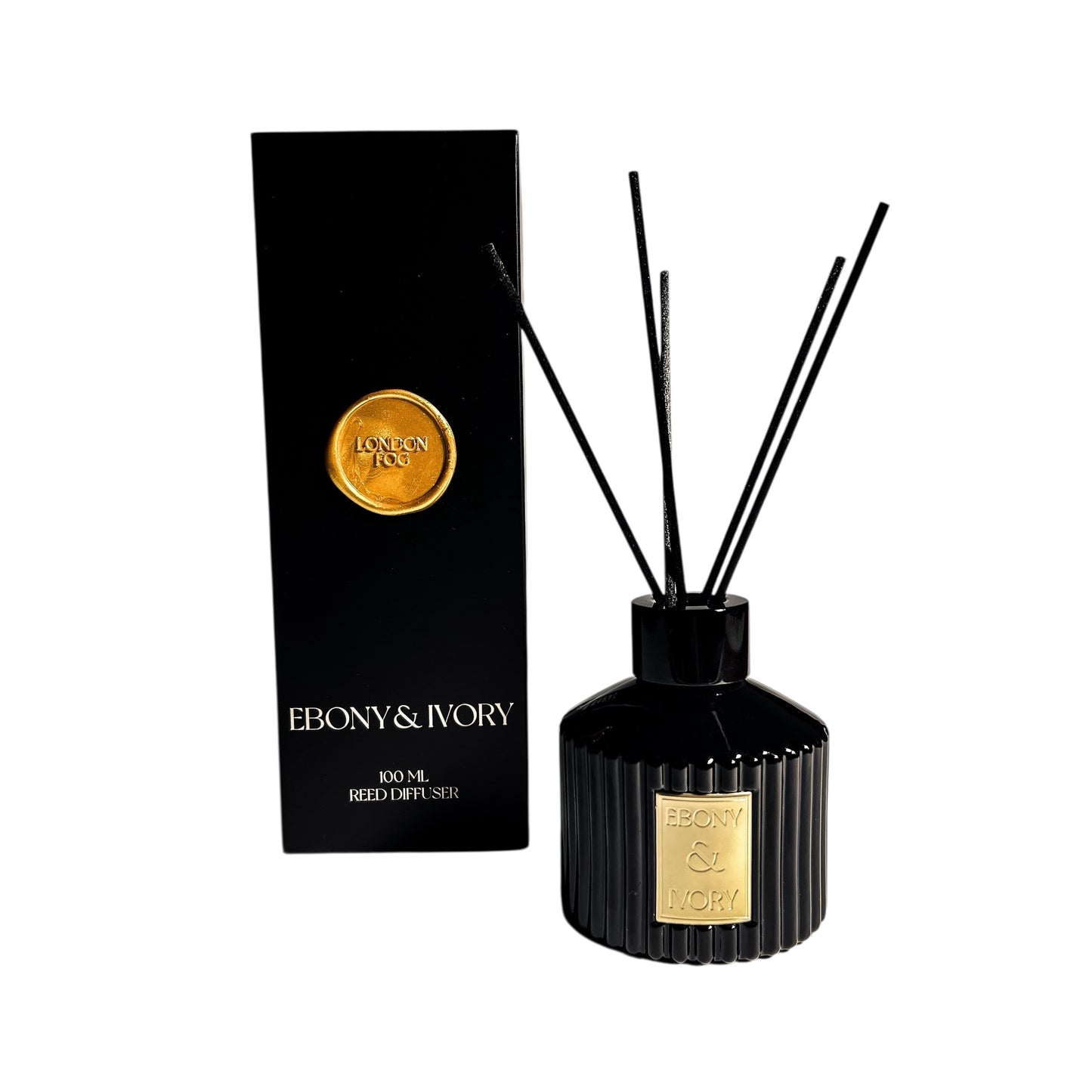 A black ribbed 100ml reed diffuser with a gold Ebony & Ivory label, sitting next to a black box with a gold wax seal label named London Fog, on a white background, made by Ebony & Ivory Candle Co in Lethbridge, Alberta, Canada