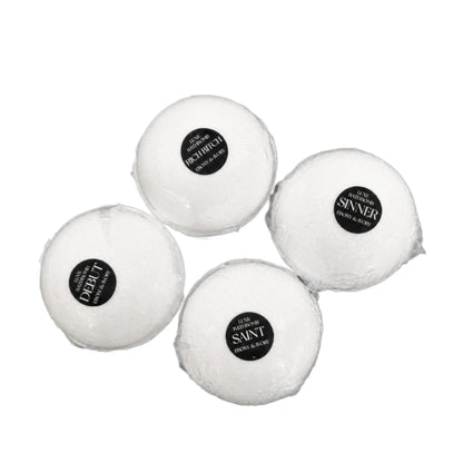 A pile of 4 luxury bath bombs with black labels named Debut, Rich Bitch, Saint, and Sinner