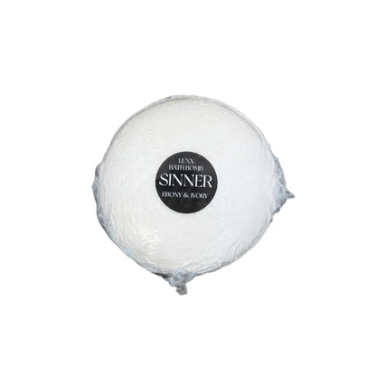 A luxury bath bomb with a black label named "sinner"