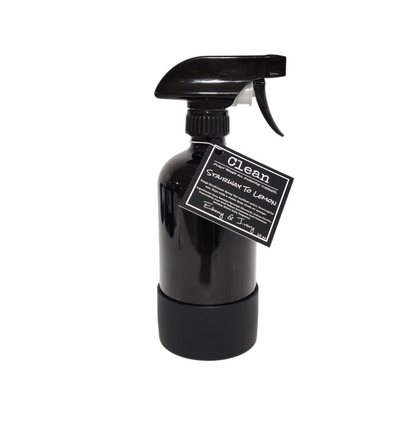 A 16oz black sprayer bottle of all purpose cleaner with a rubber bottom and a black label that reads "Stairway to Lemon" on a white background, made by Ebony & Ivory Candle Co in Lethbridge, Alberta, Canada