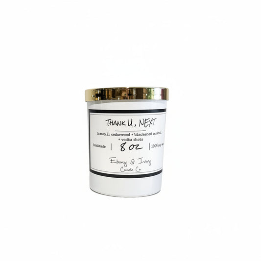 A white jar 8z soy candle with a gold lid and a white label named Thank U, NEXT, on a white background, made by Ebony & Ivory Candle Co in Lethbridge, Alberta, Canada