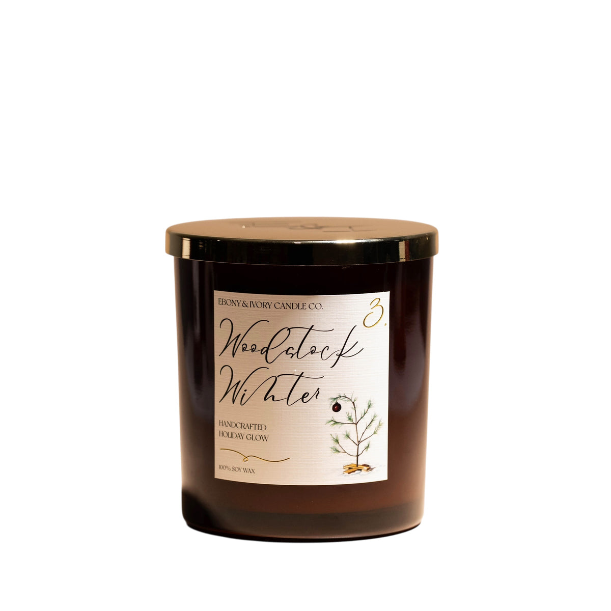 A 16oz amber soy christmas candle with a gold lid a white label named "woodstock winter"