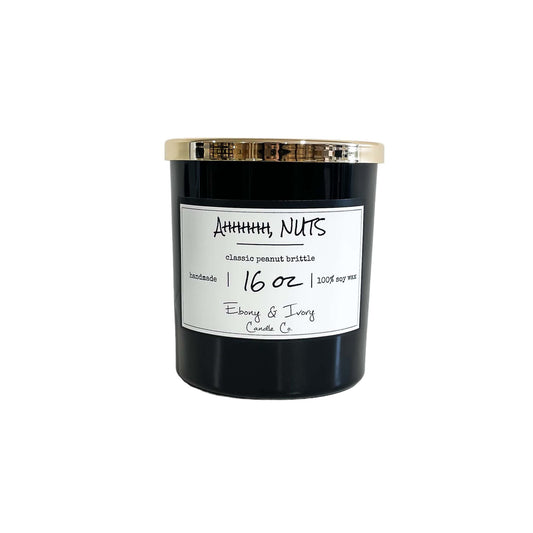 A black 16oz soy candle with a gold lid and a white label named "Ahhhhh NUTS"