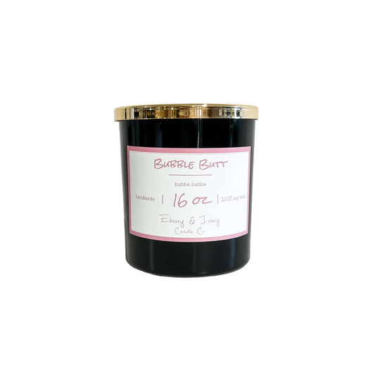 A black 16oz jar soy candle with a gold lid and a white label named Bubble Butt on a white background, made by Ebony & Ivory Candle Co in Lethbridge, Alberta, Canada