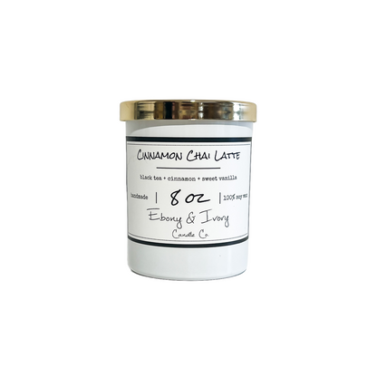 a white 8oz soy wax candle with a gold lid and a white label named "cinnamon chai latte"