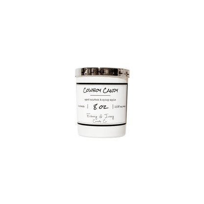 A white 8oz jar soy candle with a gold lid and a white label named Cowboy Candy on a white background, made by Ebony & Ivory Candle Co in Lethbridge, Alberta, Canada