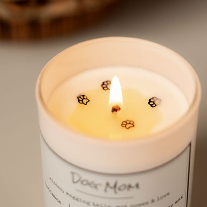 A top down of a white 8oz soy candle labelled Dog Mom with four paw print glitters on top of the wax. Made in Lethbridge Alberta Canada