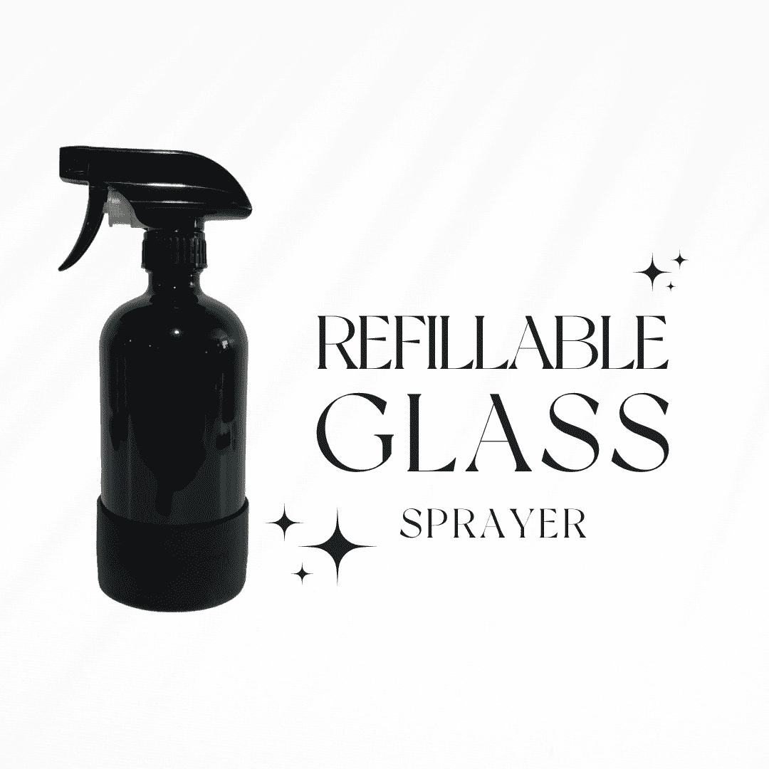 A empty black 16oz refillable sprayer bottle with a rubber bottom on a white background with black text that reads "Refillable glass sprayer" by Ebony & Ivory Candle Co in Lethbridge, Alberta, Canada