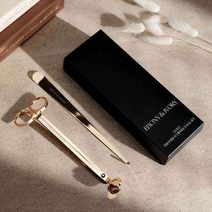 A black box for a set of 2 candle tools. The tools are a gold wick trimmer and a gold wick dipper with white Ebony & Ivory logos
