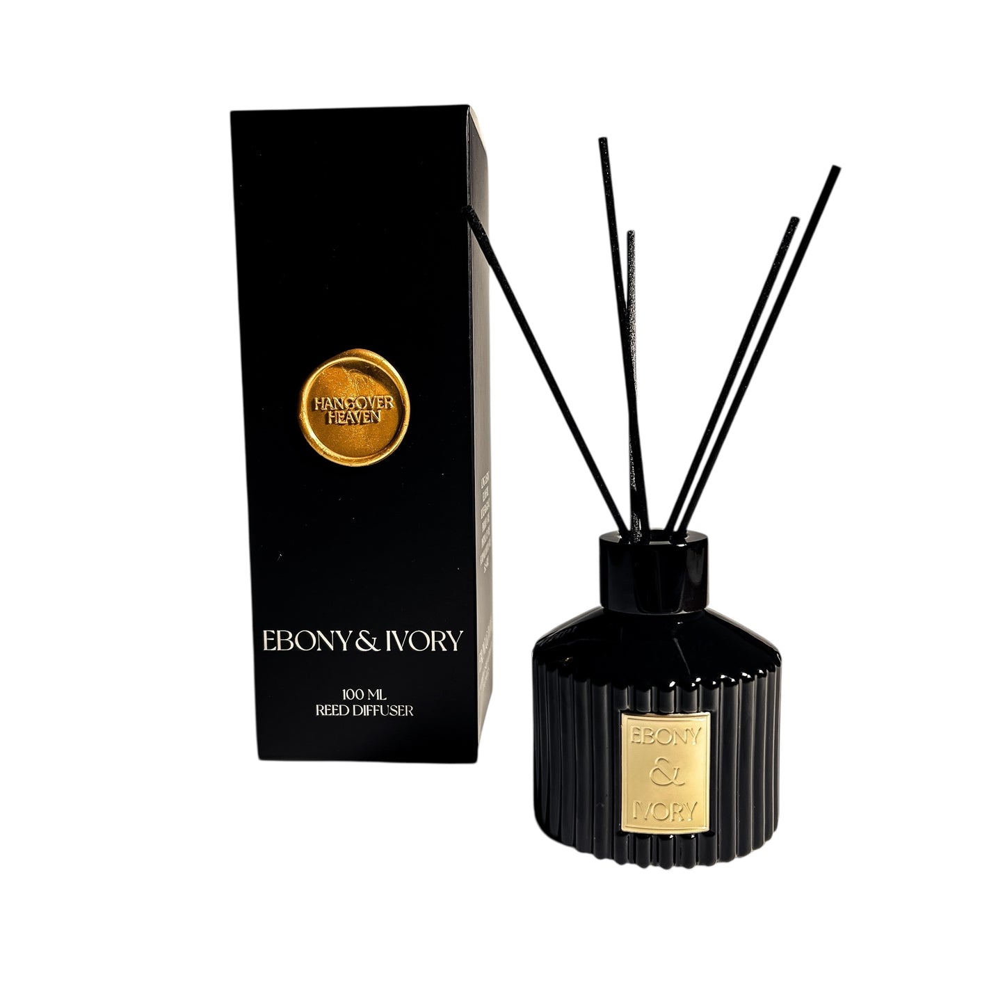 A black 100ml ribbed reed diffuser with a gold ebony & Ivory label, next to a black box with a gold wax seal label named Hangover Heaven, on a white background, made by Ebony & Ivory Candle Co in Lethbridge, Alberta, Canada
