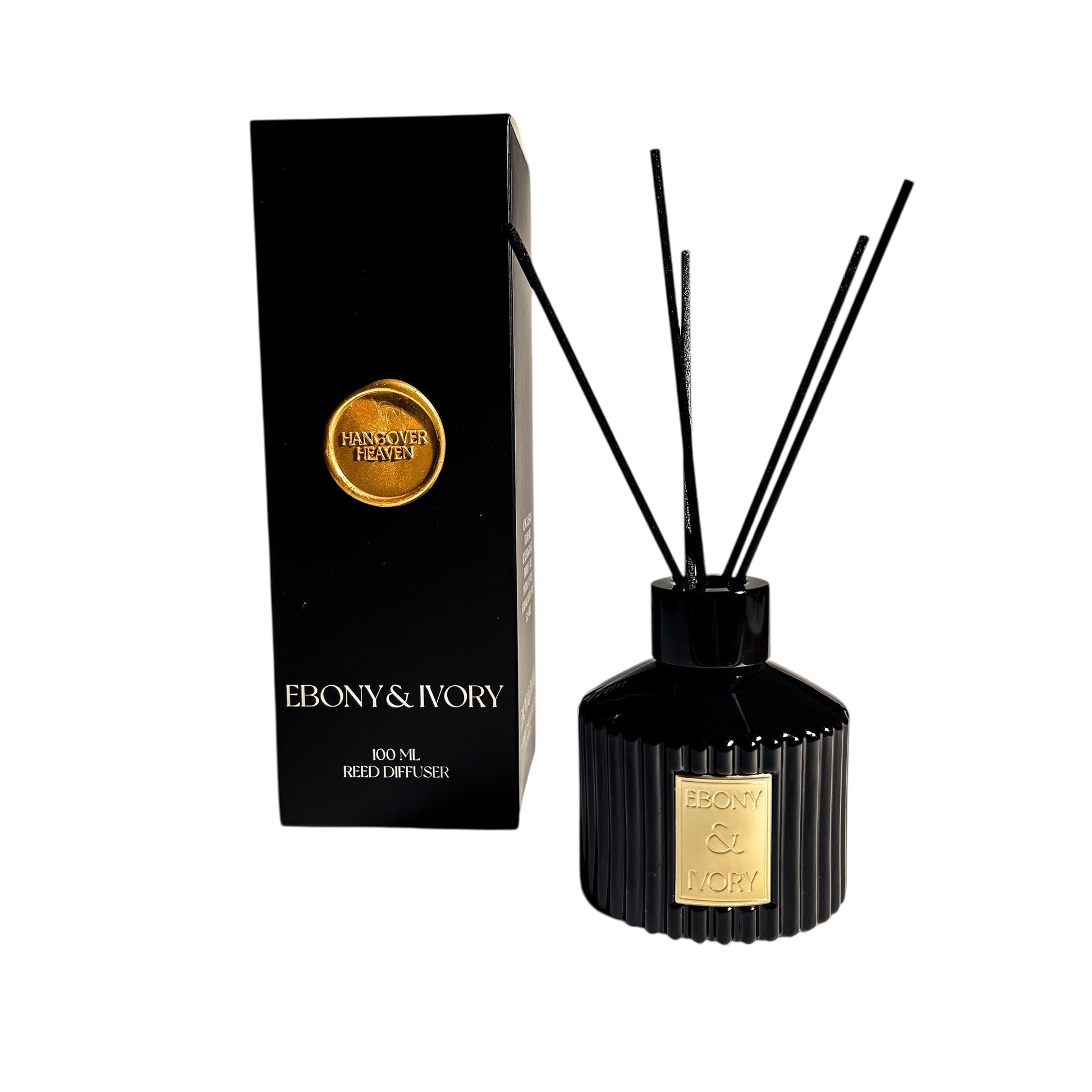 A black 100ml ribbed reed diffuser with a gold ebony & Ivory label, next to a black box with a gold wax seal label named Hangover Heaven, on a white background, made by Ebony & Ivory Candle Co in Lethbridge, Alberta, Canada