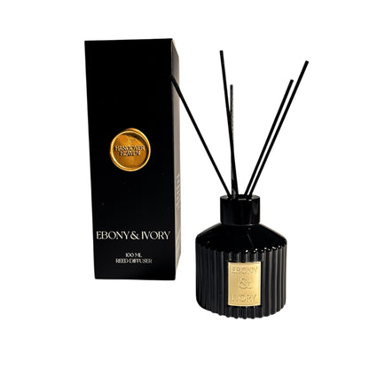 A black 100ml ribbed reed diffuser with a gold ebony & Ivory label, next to a black box with a gold wax seal label named Hangover Heaven, on a white background, made by Ebony & Ivory Candle Co in Lethbridge, Alberta, Canada
