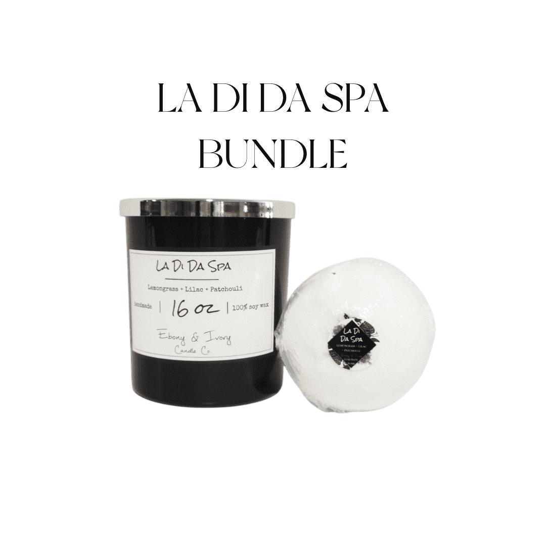 A black jar 16oz soy candle with a gold lid and a white label named La Di Da Spa, sitting next to a white bath bomb with hibiscus flowers on top and a round label named La Di Da Spa, on a white background, made by Ebony & Ivory Candle Co in Lethbridge, Alberta, Canada