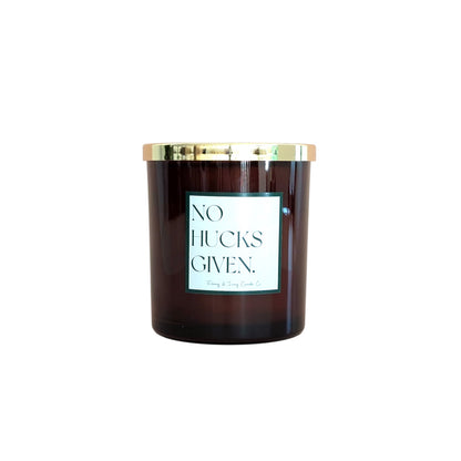 An amber jar 16oz soy candle with a gold lid and a white label named No Hucks Given, on a white background, made by Ebony & Ivory Candle Co in Lethbridge, Alberta, Canada