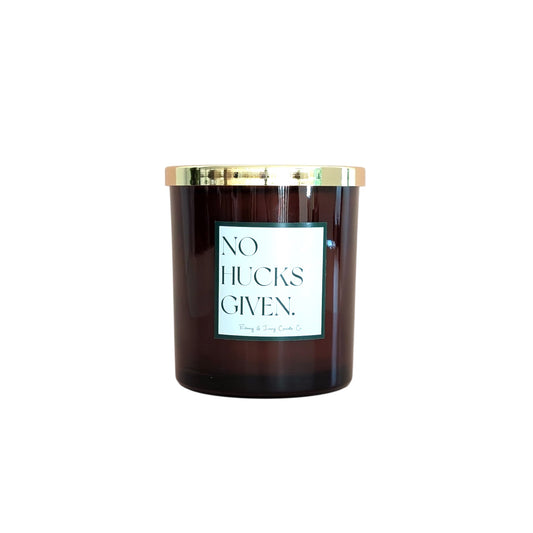 An amber jar 16oz soy candle with a gold lid and a white label named No Hucks Given, on a white background, made by Ebony & Ivory Candle Co in Lethbridge, Alberta, Canada