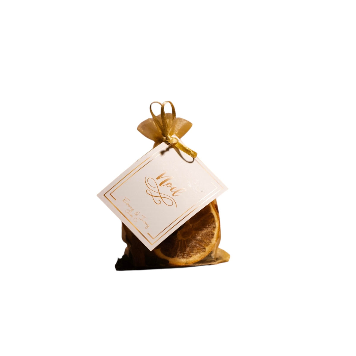 a small gold bag with a white hang tag named "noel" containing dried botanicals for a simmer pot.