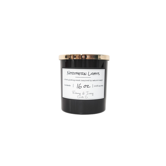 A black jar 16oz soy candle with a gold lid and a white label named Northern Lights, on a white background, made by Ebony & Ivory Candle Co in Lethbridge, Alberta, Canada