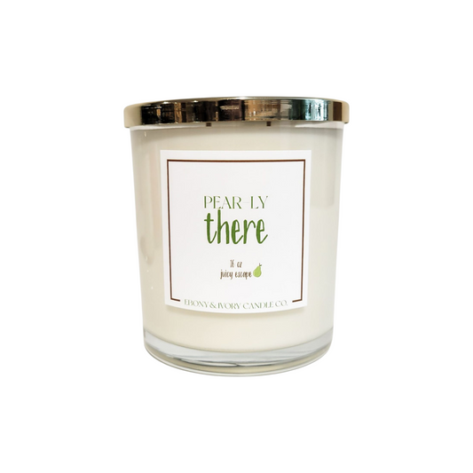 A clear glass 16oz soy candle with a gold lid and a white label named "Pear-ly There," Mae by Ebony & Ivory Candle Co in Lethbridge Alberta Canada