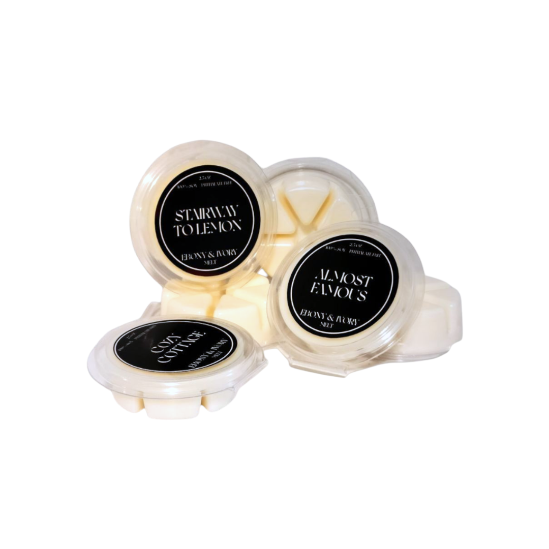 A pile of Ebony & Ivory Candle Co's 2.5oz clear clam shell luxx wax tarts on a white background, made in Lethbridge, Alberta, Canada