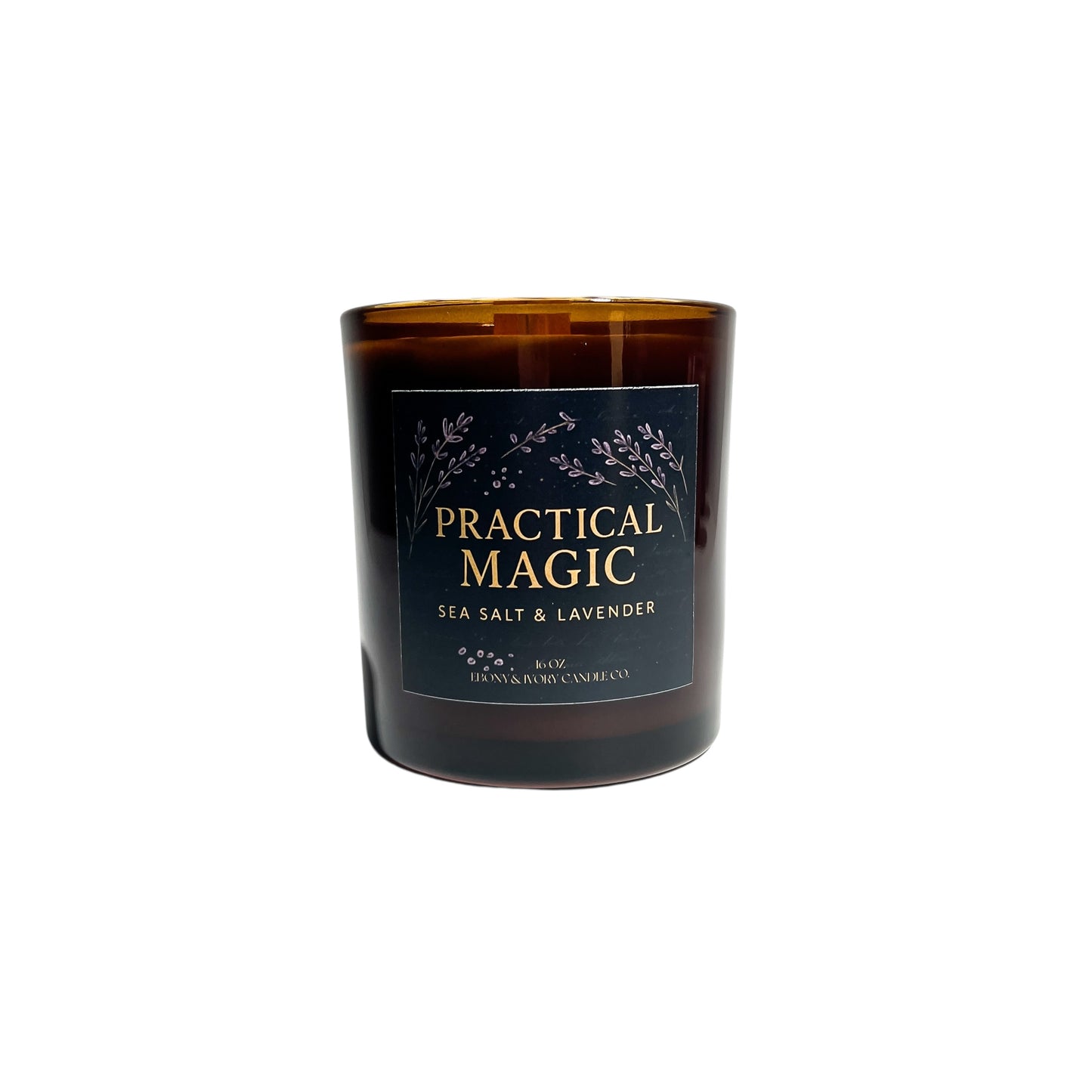 An amber jar 16oz soy wax candle with a wood wick, a gold lid, and an indigo label named "practical magic"
