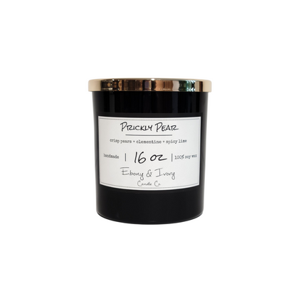 A black 16oz soy candle with a gold lid and a white label named "Prickly Pear." Made by Ebony & Ivory Candle Co in Lethbridge Alberta Canada