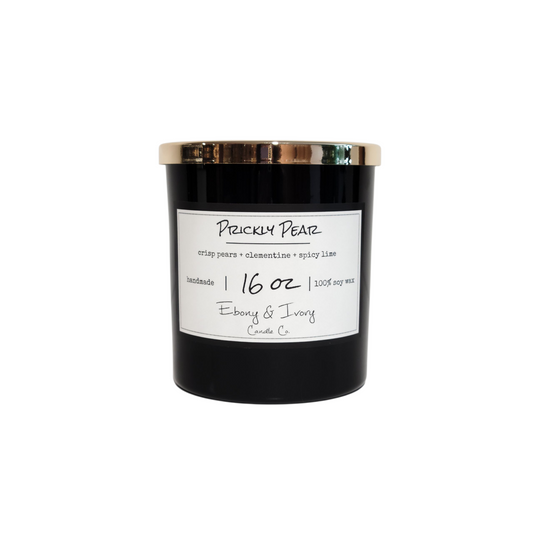 A black 16oz soy candle with a gold lid and a white label named "Prickly Pear." Made by Ebony & Ivory Candle Co in Lethbridge Alberta Canada