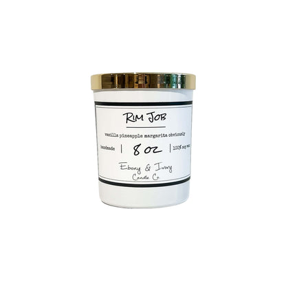 a white 8oz soy candle with a gold lid, labelled Rim Job, on a white background. Made in Lethbridge, Alberta, Canada