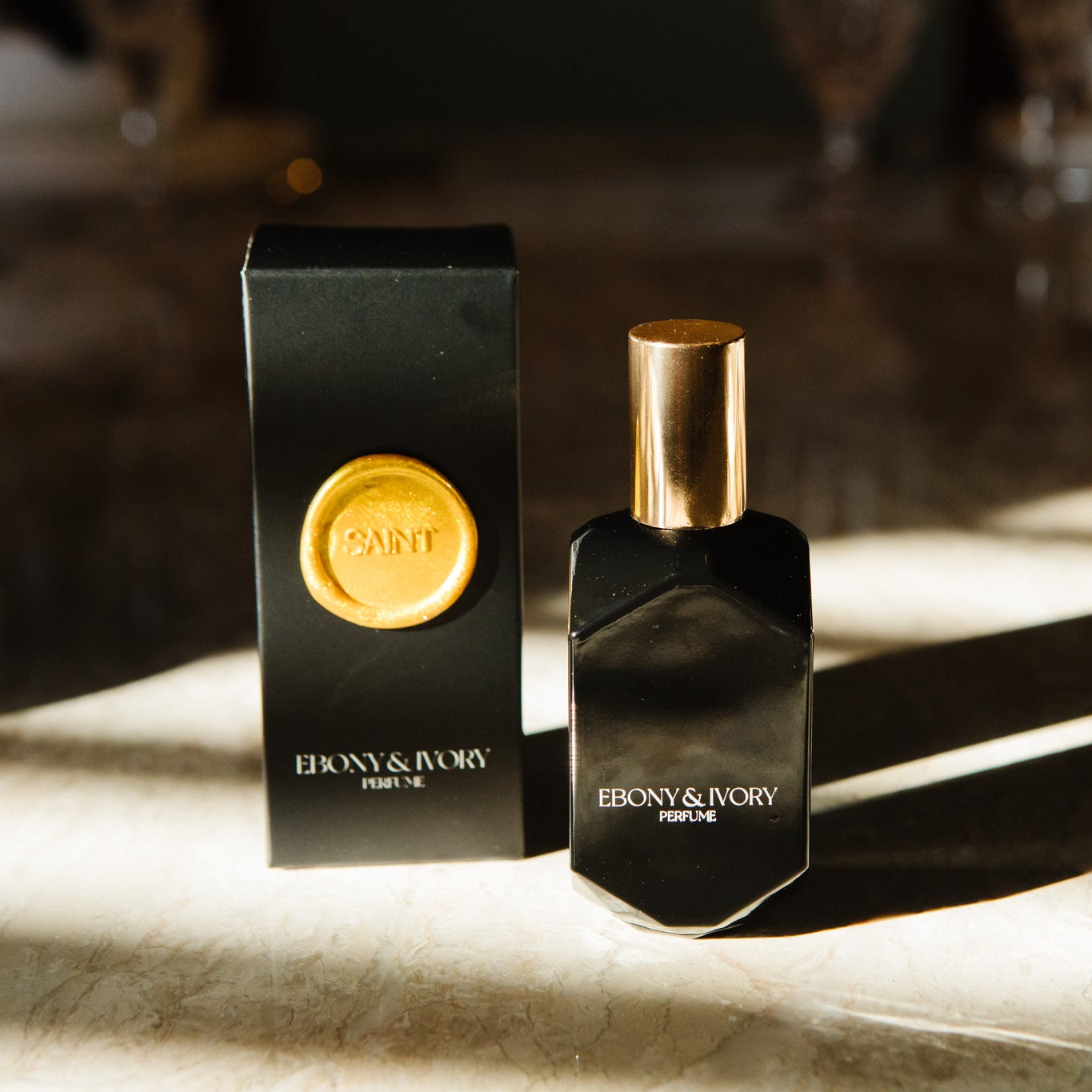 Ebony & Ivory perfume bottle and packaging on a textured surface with soft lighting.
