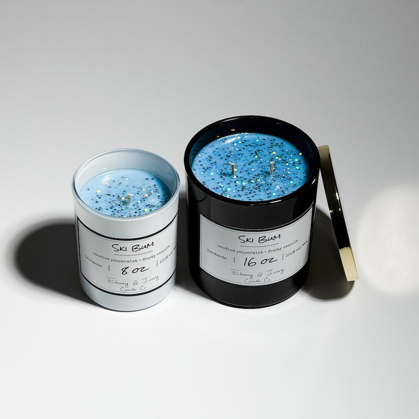 A black and white jar candle with gold lid. Labelled Ski Bum, a candy vanilla peppermint soy wax candle. Canadian made candle. Healthy Candle.