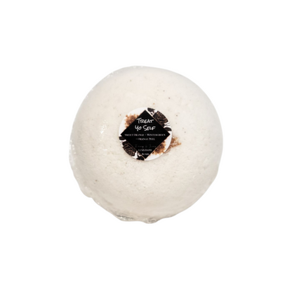 A white bath bomb with a round sticker label named Treat Yo Self, on a white background, made by Ebony & Ivory Candle co in Lethbridge, Alberta, Canada