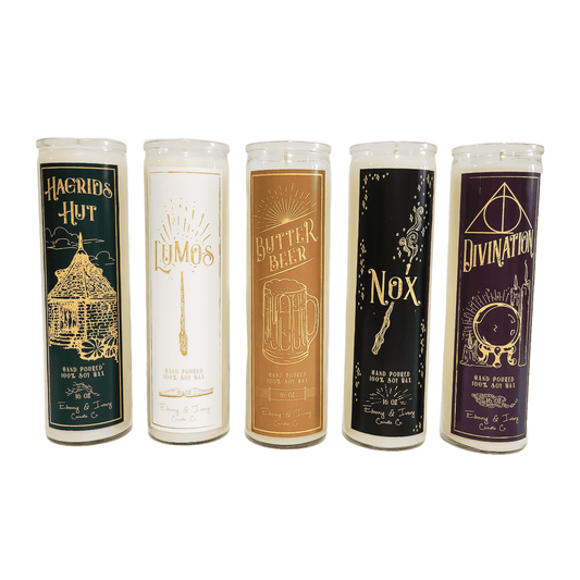 5 tall, clear, 16oz soy candles, one with a green label named Hagrid's Hut, one with a white label named Lumos, one with a gold label named Butter Beer, one with a black label named Nox, and one with a purple label named Divination. All apart of the wizarding candle collection made by Ebony & Ivory Candle Co in Lethbridge, Alberta, Canada